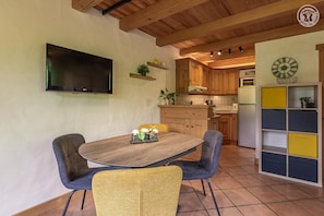 A kitchen with wooden cabinets, a built-in oven, and a wall-mounted TV. - Le Petit Riondet - SAINT NICOLAS LA CHAPELLE (SAINT NICOLAS LA CHAPELLE)