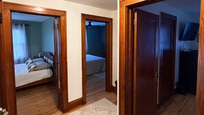 Un couloir doté d’un plancher en bois, d’un tapis à motifs et d’un luminaire au plafond.