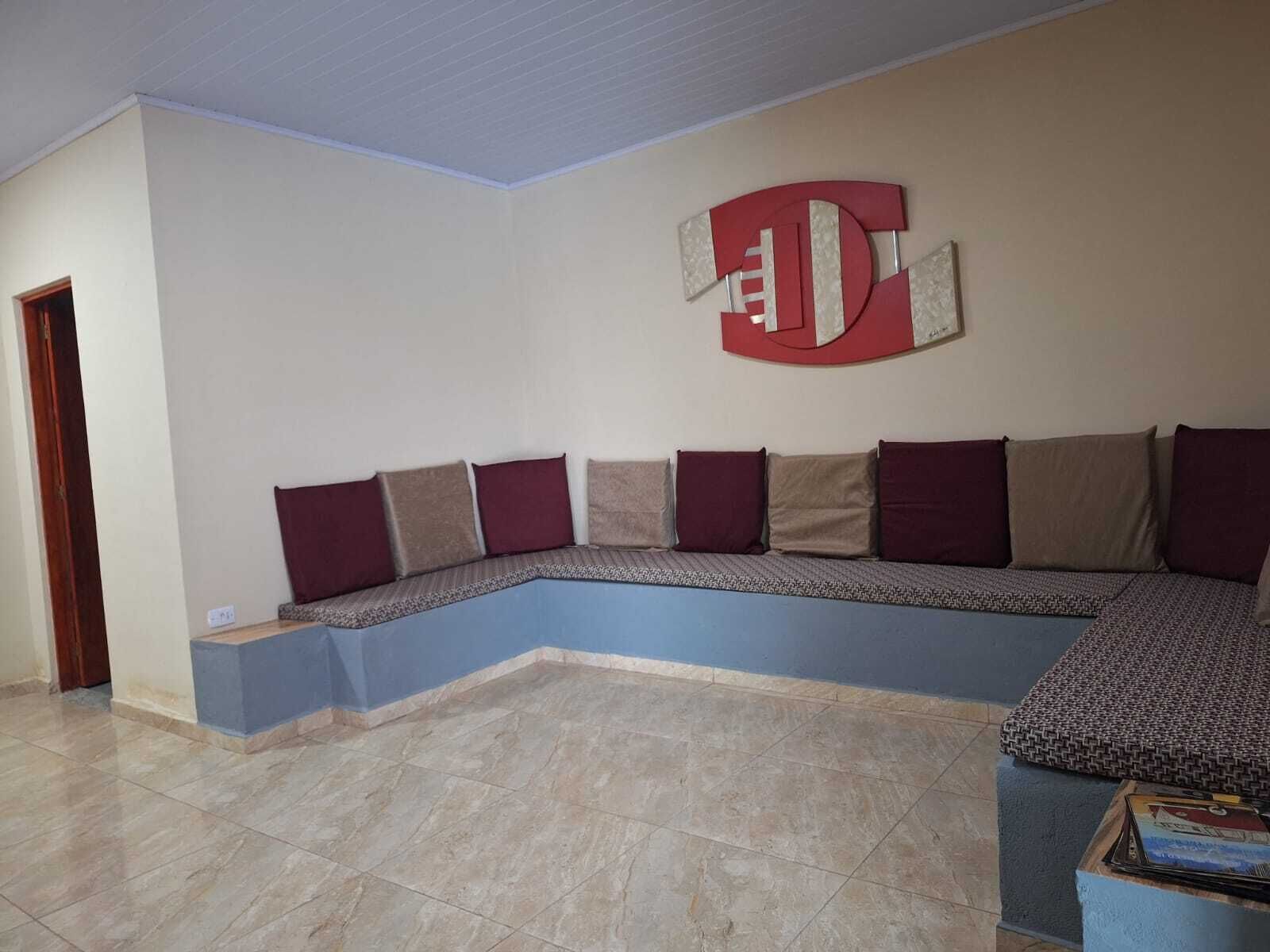A corner seating area with a built-in bench, a patterned rug, and a wall-mounted artwork.