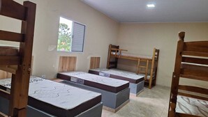 A dormitory room with bunk beds, a window, and a ceiling light. - Sitio toa toa 2 (São roque)