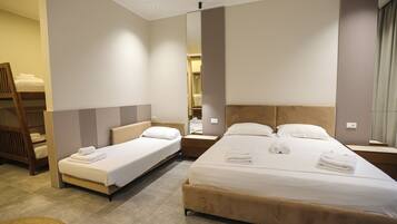 A hotel room with two beds, a large mirror, and a wooden chair.