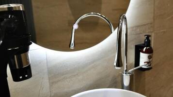 Un bagno con un lavabo in marmo, un rubinetto e un erogatore di sapone.