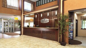 A hotel reception area with a sign reading "Crystal Inn Hotel Suites". There is a reception desk, a cash register, and a plant near the entrance. - 2 Pet-Friendly Units w/ Free Breakfast, Airport Shuttle & Indoor Pool Access (Salt Lake County)