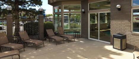 An outdoor patio area with lounge chairs and a pool.