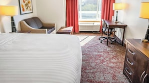 A hotel room with a bed, desk, chair, and a view of the outdoors. - Downtown SLC Retreat w/ Indoor Pool, Free Breakfast & Parking | Pets Are Welcome (Salt Lake County)