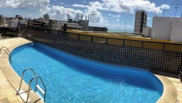 A rooftop swimming pool with a clear view of the city skyline. - Fully furnished apartment 2 blocks from Ponta Verde beach. (Maceió)