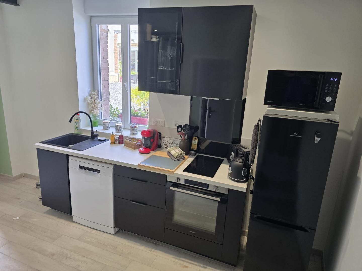 A modern kitchen with a dishwasher, oven, microwave, and refrigerator.