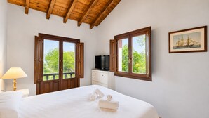 A bedroom with a bed, two windows, a television, a painting, and a lamp. - Villa Los Bufones de Pria (Llames De Pria)