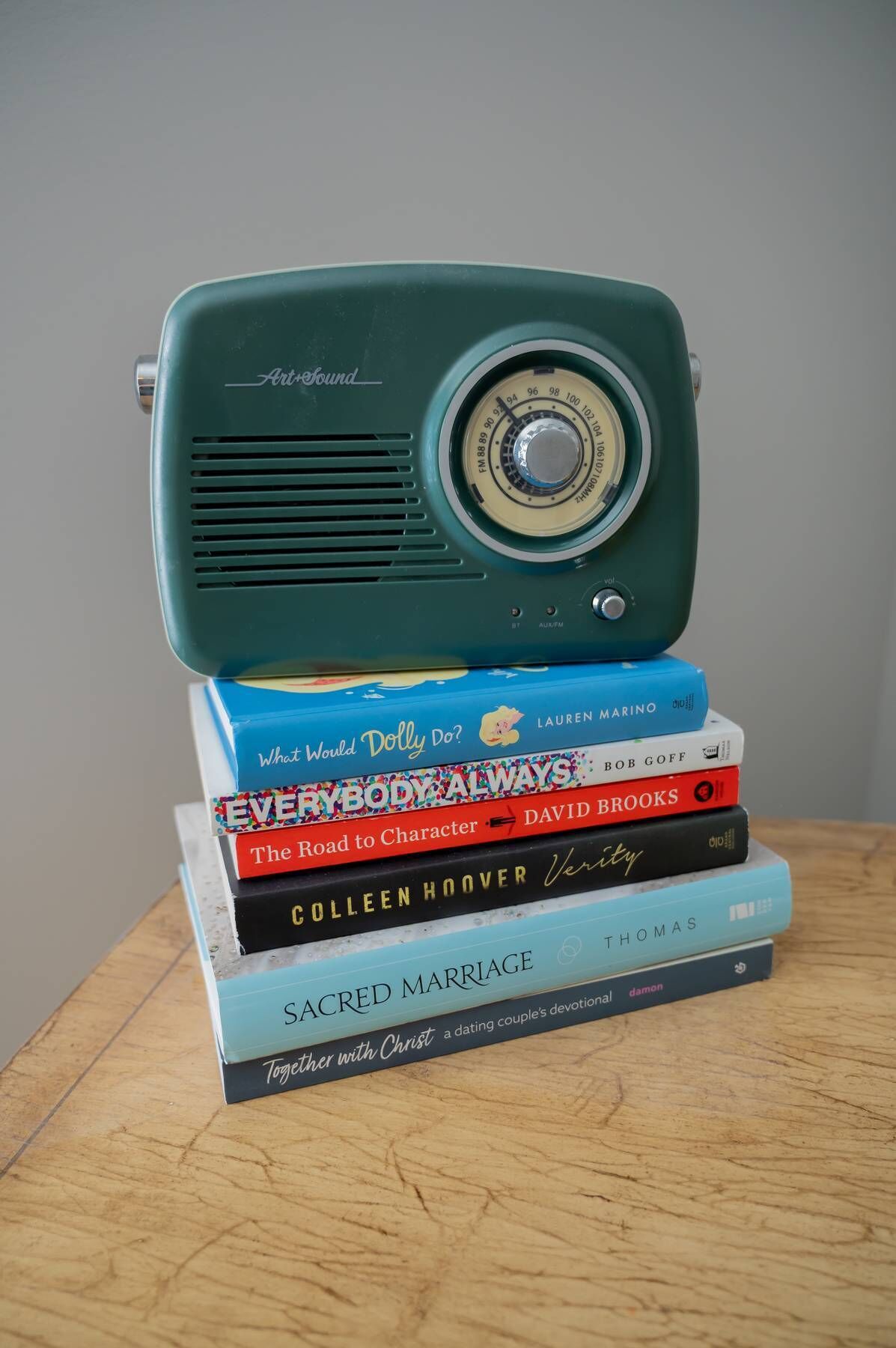 A stack of books with a vintage radio on top.