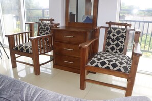 A room with a wooden dresser, two chairs with patterned cushions, and a large window. - The Kumatha Residence ,1st Floor one bedroom apartment ,350m to beach/pool view (Palangature  Negombo)