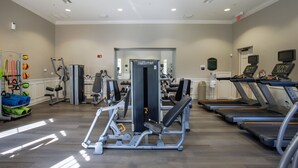 A gym with treadmills, weight machines, and exercise balls.