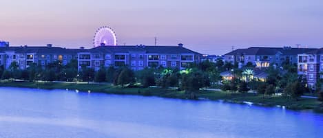 A waterfront hotel with a Ferris wheel in the background.