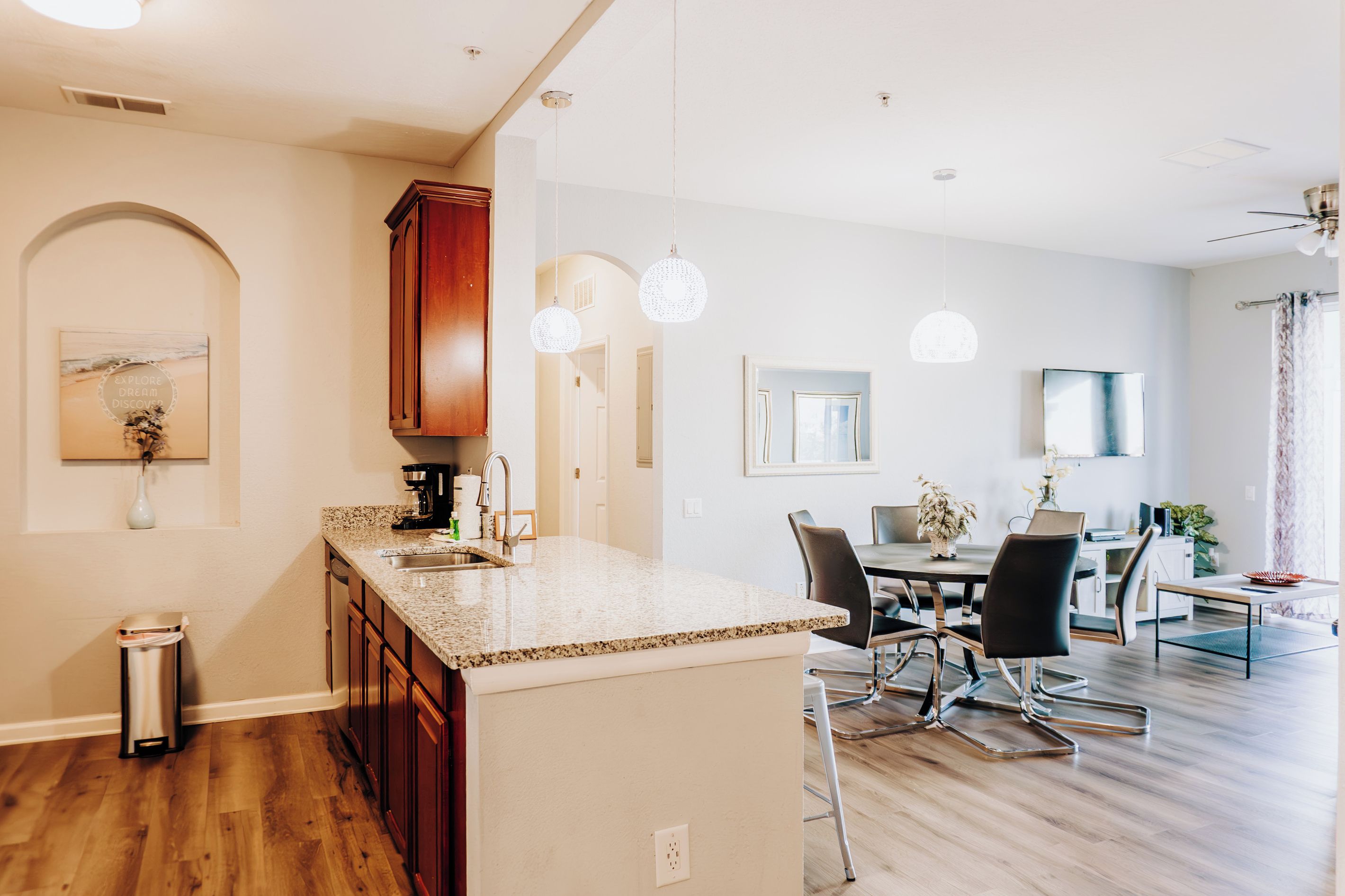 A modern kitchen with granite countertops, wooden cabinets, and a central island.