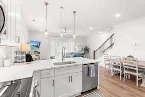 A modern kitchen with a central island, stainless steel appliances, and pendant lighting. - Walk to Beach | Brand New Luxury Home Myrtle Beach (Myrtle Beach)