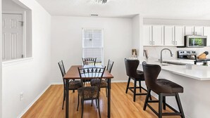 A modern kitchen with white cabinets, a stainless steel sink, and a built-in microwave.