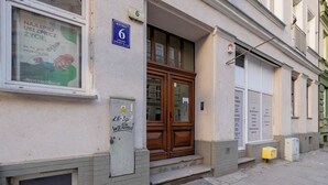 Rakennuksessa on puuovi, ikkunassa on juliste ja sen vieressä on numerokyltti.