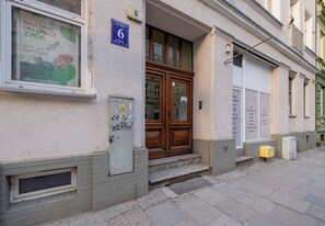 Ein Gebäude mit einer Holztür, einem Fenster mit einem Plakat und einem Hinweisschild.