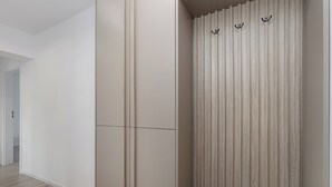 Ein modernes Interieur mit Holzboden, weißer Wand und einer Wandverkleidung aus Holz mit Haken.