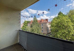 A balcony with a view of buildings and trees.