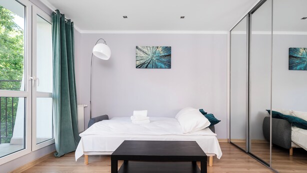 Ein modernes Schlafzimmer mit Bett, Nachttisch und Bildern an den Wänden.