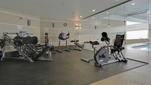 A gym with various exercise equipment, including treadmills and weight machines. - Breathtaking 20th Floor Skyline Views in the Heart of Downtown Calgary (Calgary)