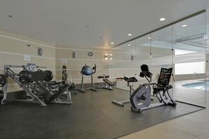 A gym with various exercise equipment, including treadmills and weight machines. - Breathtaking 20th Floor Skyline Views in the Heart of Downtown Calgary (Calgary)