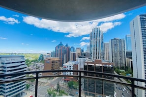 A cityscape with high-rise buildings, a clear sky, and a view from a balcony. - Breathtaking 20th Floor Skyline Views in the Heart of Downtown Calgary (Calgary)