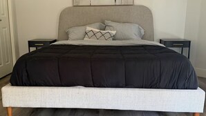 A bed with a black and white striped bedspread, two bedside tables, and a headboard. - Breathtaking 20th Floor Skyline Views in the Heart of Downtown Calgary (Calgary)
