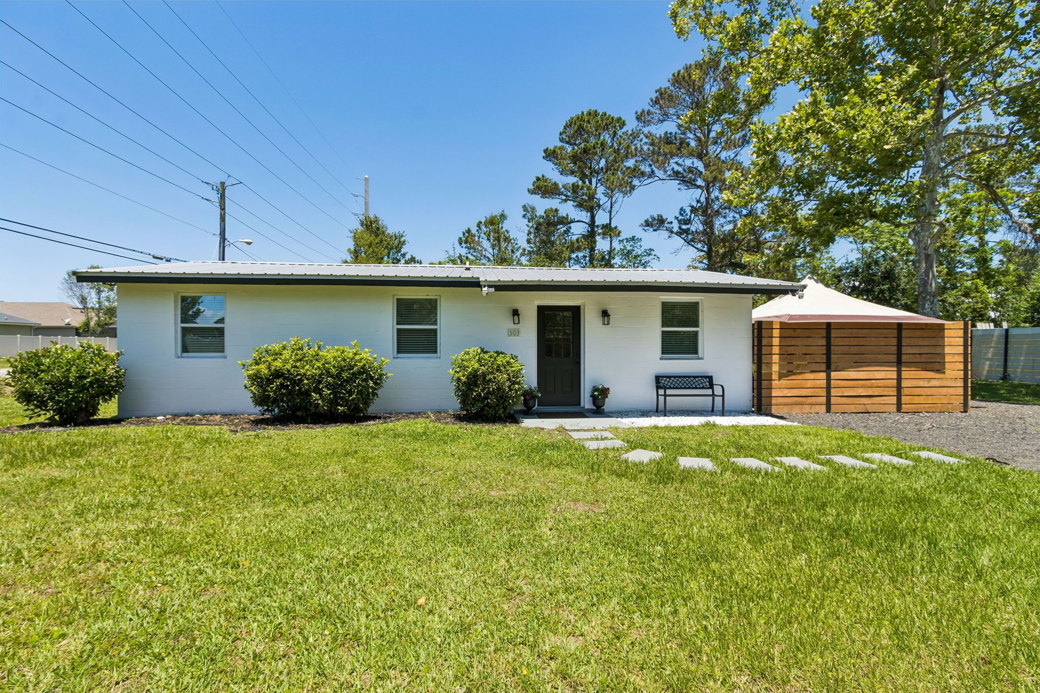 A single-story house with a front porch, a small attached garage, and a well-maintained lawn.