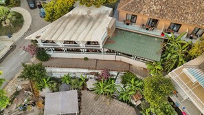 A multi-story building with a rooftop terrace, a swimming pool, and a garden area with various plants. - Hotel Platinium Dhermi (Dhermi)