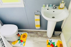 Een badkamer met toilet, wastafel en een handdoekrek met een patroon.