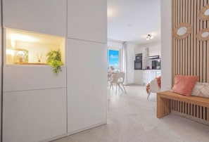 Ein moderner Wohnraum mit Küche, Essbereich und einer Sitzecke mit einer Bank.