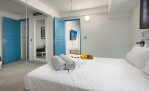 Ein Hotelzimmer mit Bett, Fernseher, Tür und Spiegel.