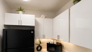 A modern kitchen with white cabinets, a black refrigerator, a microwave, and a sink. -  Cozy coastal stay in Fort Lauderdale near las olas,Wilton manors,airport,Port (Fort Lauderdale)