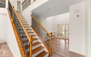 A staircase with wooden steps and black railings leading to a second floor. - Pet-Friendly Loganville Retreat • Near Parks (Loganville)