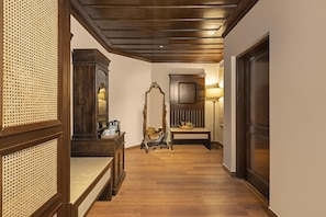 A hallway with wooden flooring, a mirror, a bench, and a lamp. - Brij Anayra Dharamshala (Dharamshala)