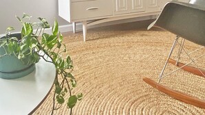 Habitació amb un armari blanc, televisió, un quadre amb marc i plantes en testos.