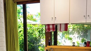 A compact kitchen with a wooden countertop, a sink, and a dishwasher.