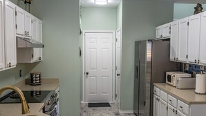 A kitchen with white cabinets, a stainless steel refrigerator, a microwave, and a stove. - Quiet Neighborhood walking by eagle creek close to downtown and speedway (Indianapolis)