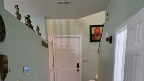 A hallway with a white door, a carpeted staircase, and a rug on the floor. - Quiet Neighborhood walking by eagle creek close to downtown and speedway (Indianapolis)