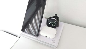 Ein Laptop zusammen mit einer weißen Maus und einer schwarzen Smartwatch auf einer weißen Oberfläche.