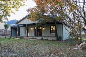 A single-story house with a porch, a small front yard, and a tree with autumn leaves. - The Rustic Charm (Midlothian)