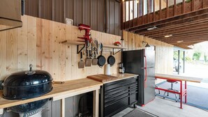 A kitchen with a built-in grill, wooden cabinets, and a red table. - Brand NEW Bungalow in Eatonville - Near Mt. Rainier (Eatonville)