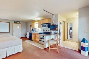 A compact room with a kitchenette, a bed, and a chair. - Dells Vista - Spa Retreat to Hot Tub (Wisconsin Dells)