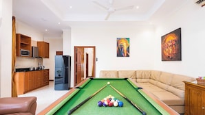 A pool table with balls, a sofa, a kitchen with cabinets, a microwave, and a refrigerator. - Luxury 4BR Pool Villa Pratamnak Soi5 - 50m to Beach (Pattaya)