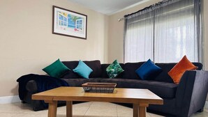 A living room with a dark-colored sofa, a wooden coffee table, and a framed picture on the wall.