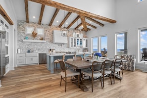 A spacious kitchen with a large island, wooden beams, and a view to the outside. - Beautiful 4BR Beachfront | Elevator + Game Room (Port Bolivar)