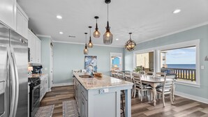 A kitchen with a central island, stainless steel appliances, and pendant lighting. - Beachfront 5BR | Sleeps 16 | Fully Fenced Pet Friendly (Port Bolivar)