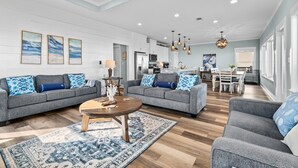A spacious living area with two grey sofas, a coffee table, and a patterned rug. - Beachfront 5BR | Sleeps 16 | Fully Fenced Pet Friendly (Port Bolivar)