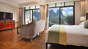 Une chambre d’hôtel avec un grand lit, une baignoire ancienne, une télévision et une armoire rouge.